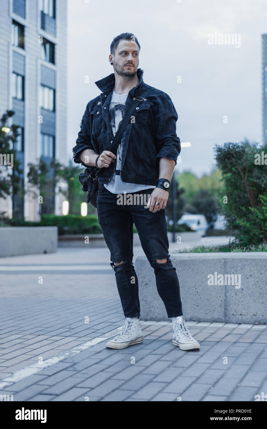 tabaco Matemático Recepción Atractiva joven hombre chaqueta jeans en negro sobre fondo permanente del  paisaje urbano Fotografía de stock - Alamy