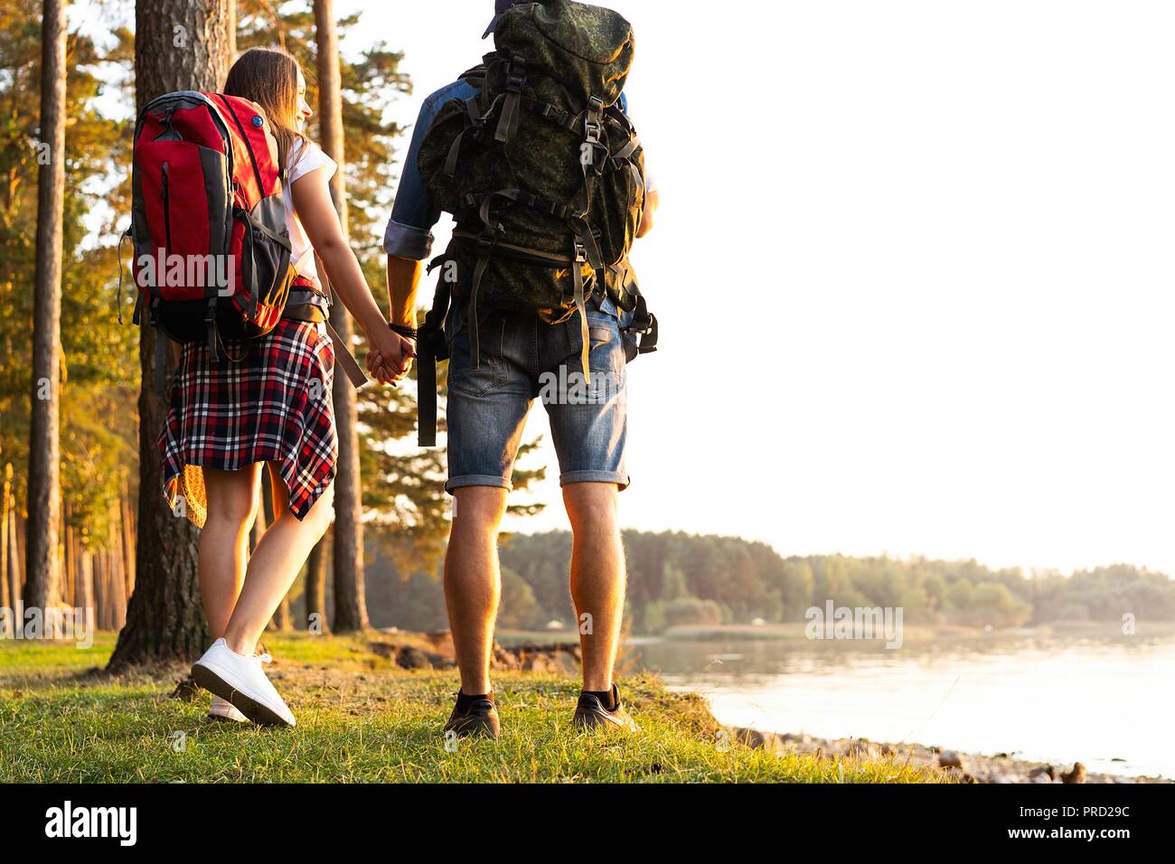 Ruta dura. Hermosa pareja joven senderismo juntos en el bosque mientras disfruta de su viaje. Foto de stock