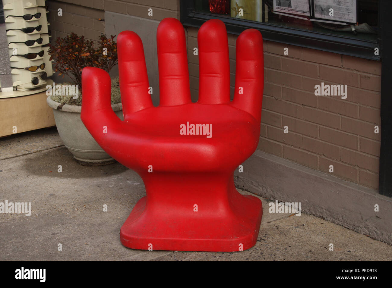 Silla roja con forma de mano fuera de store Fotografía de stock - Alamy