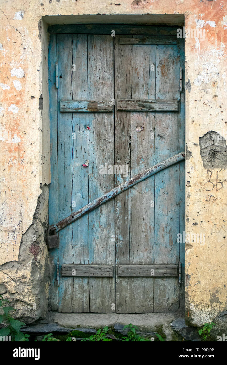 Una antigua puerta de tablas de madera rústica con desapareció la pintura  azul se encuentra en una piedra de yeso puerta amurallada Fotografía de  stock - Alamy