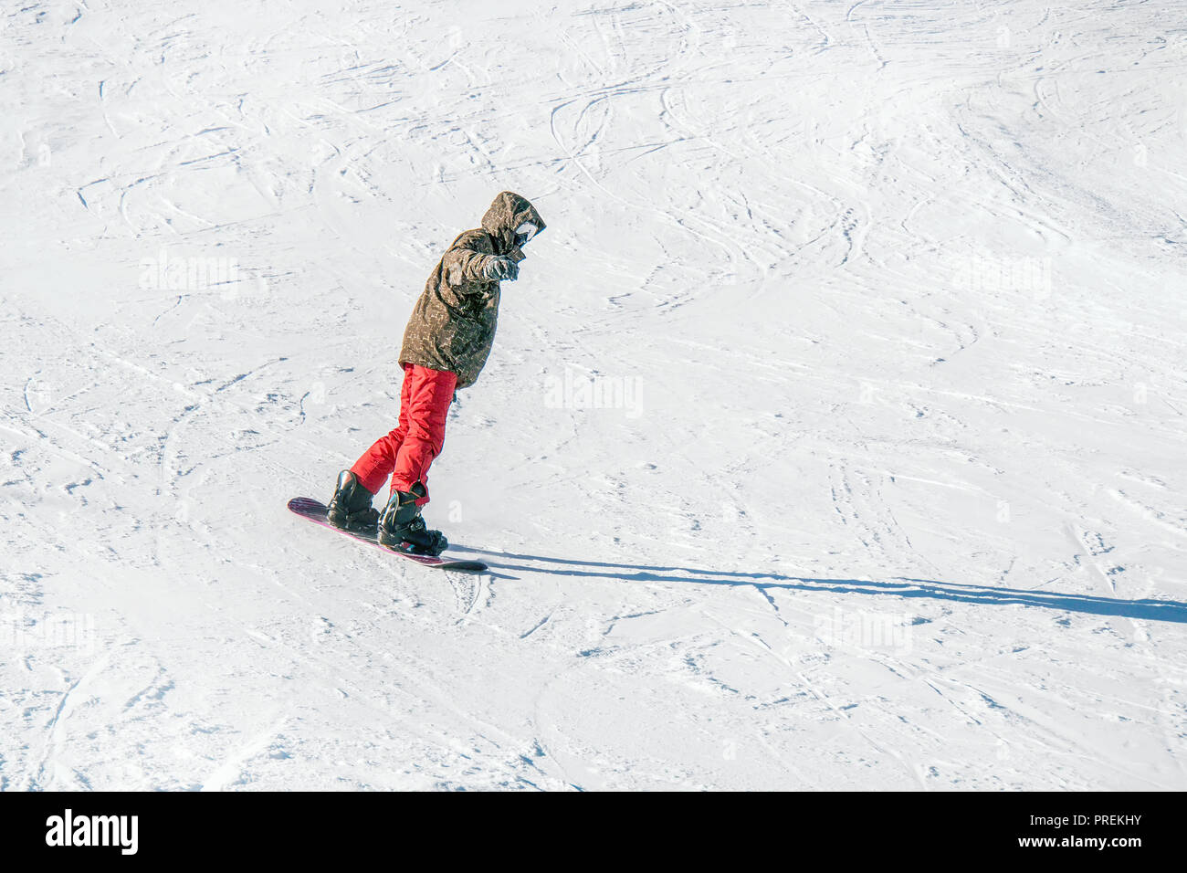 Snowboard en pantalones de color rojo en las montañas en el fondo blanco de  la nieve Fotografía de stock - Alamy