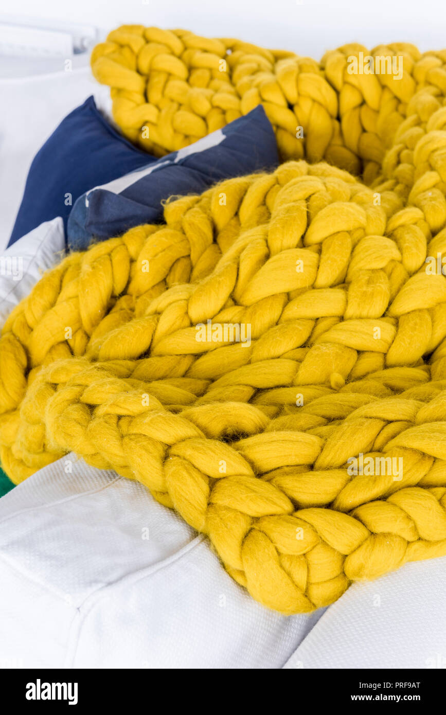 Manta de tejido grueso de color amarillo brillante en el sofá Foto de stock