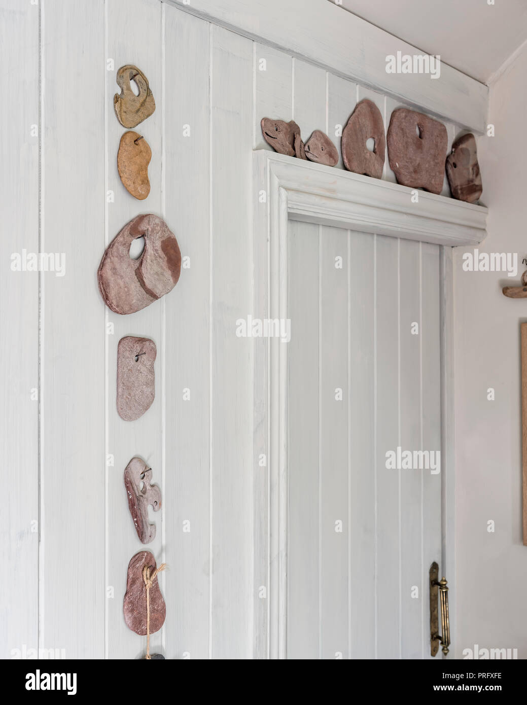 Colección de piedras montado en la pared alrededor de la puerta de la cocina en el Devon cottage Foto de stock