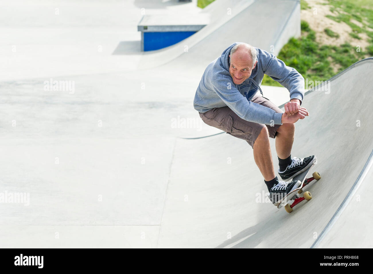 Un patinador madura disfrutando en ondas concretas Skateboard Park en Newquay en Cornualles. Foto de stock