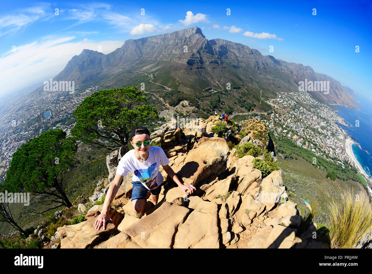Ascensión a la cabeza del león con vistas a Camps Bay, la montaña de la Mesa y los Doce Apóstoles, Ciudad del Cabo, Western Cape, Sudáfrica Foto de stock