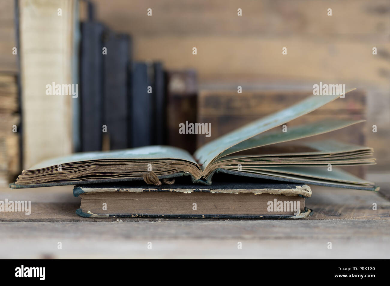 Libros antiguos y una caja de madera en un estante. Viejas casas editoriales  al lado en una mesa de madera. Fondo oscuro Fotografía de stock - Alamy