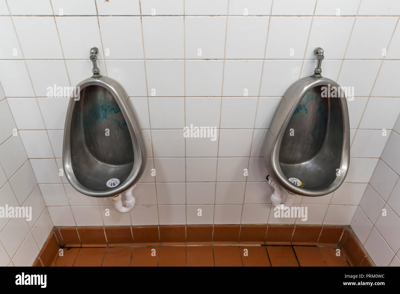 Par de urinarios en un baño público masculino en Inglaterra, Reino Unido. Foto de stock