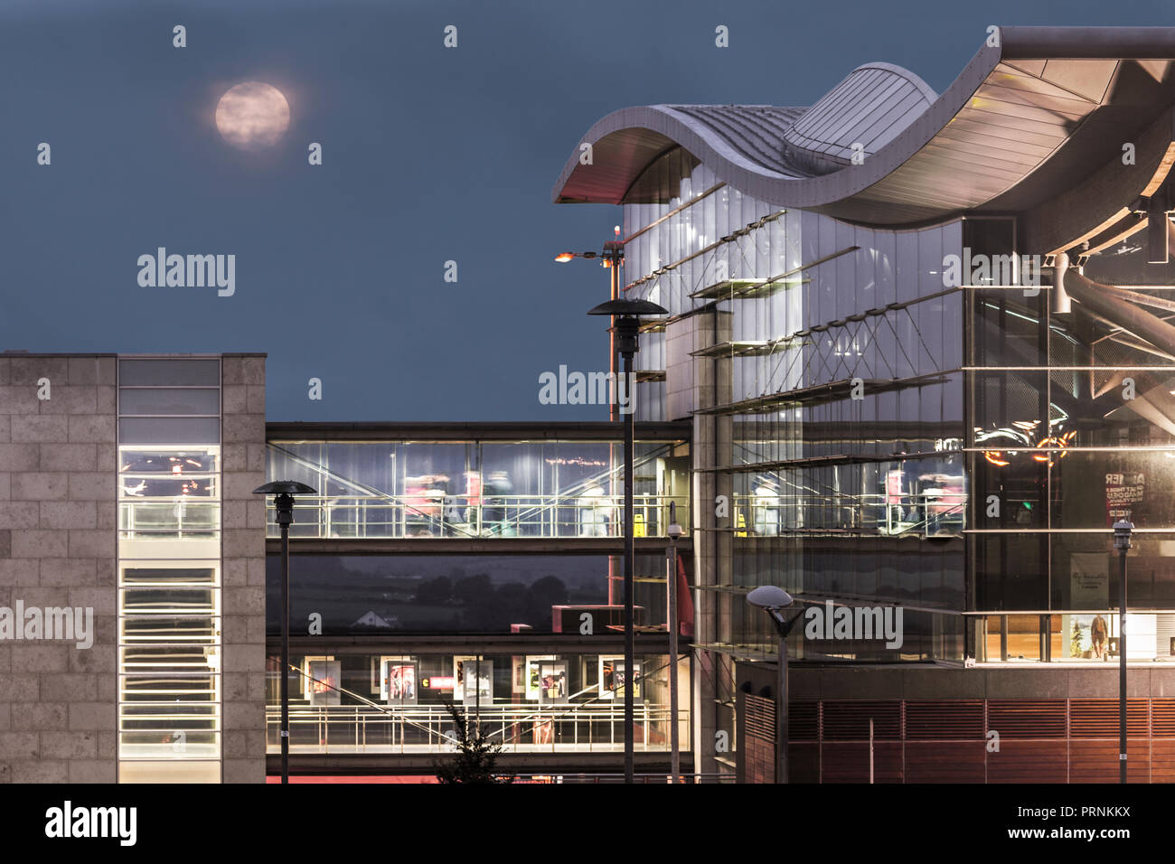 El aeropuerto de Cork, Cork, Irlanda. El 7 de septiembre, 2017. / Una luna llena desciende detrás del edificio principal de la terminal en el aeropuerto de Cork, Cork, Irlanda. Foto de stock