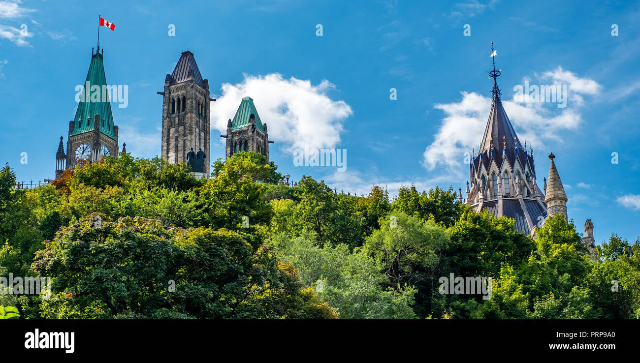 Una interesante vista de las cimas de los edificios del Parlamento canadiense incluyendo la Torre de la paz y la biblioteca, emergiendo por encima de los árboles con un beauté Foto de stock