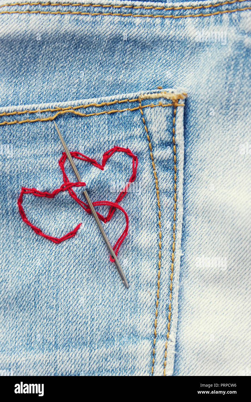 Dos corazones de madera roja en pantalones vaqueros azules - foto de stock  | Crushpixel