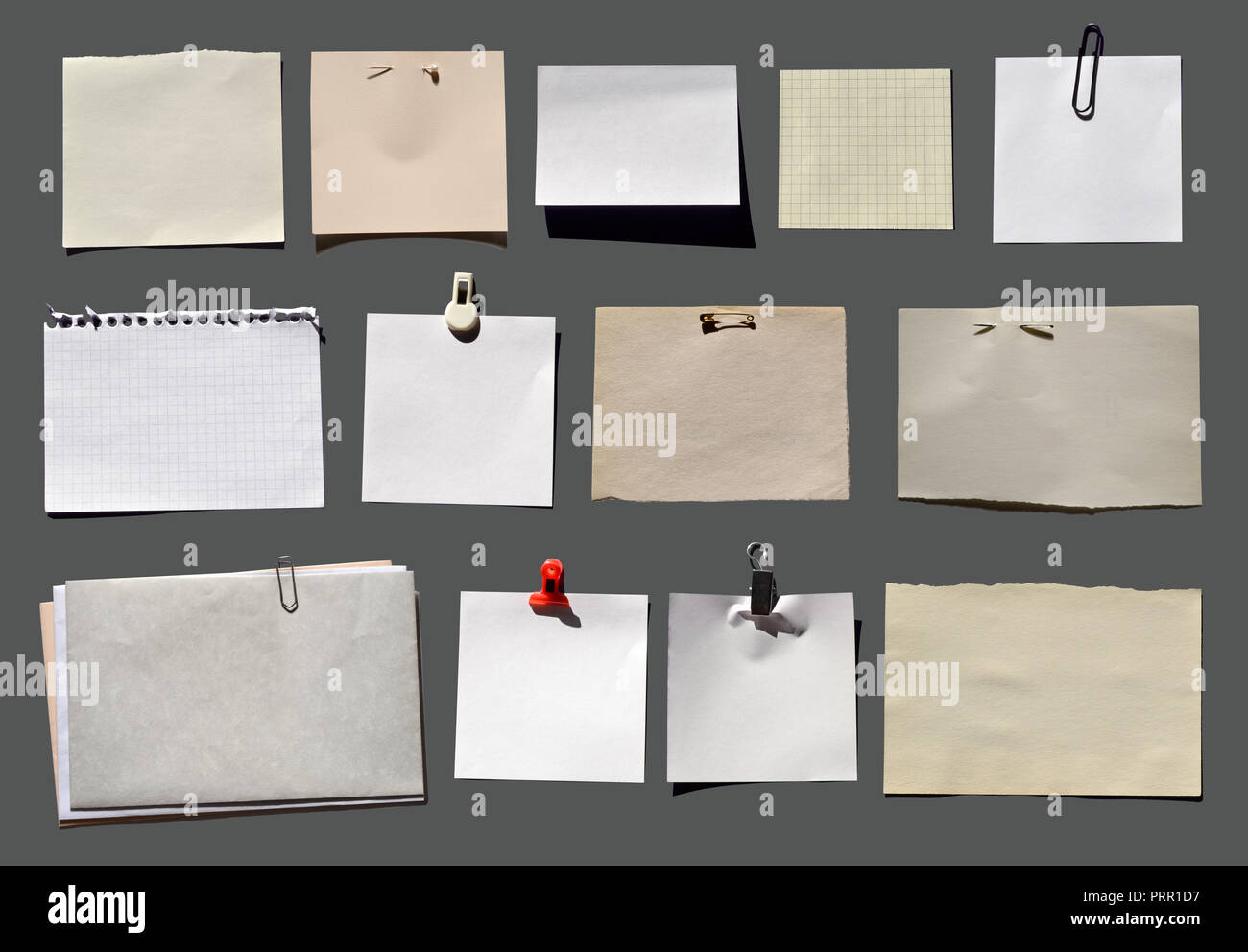 Viele verschiedene Zettel mit Halter auf grau Foto de stock
