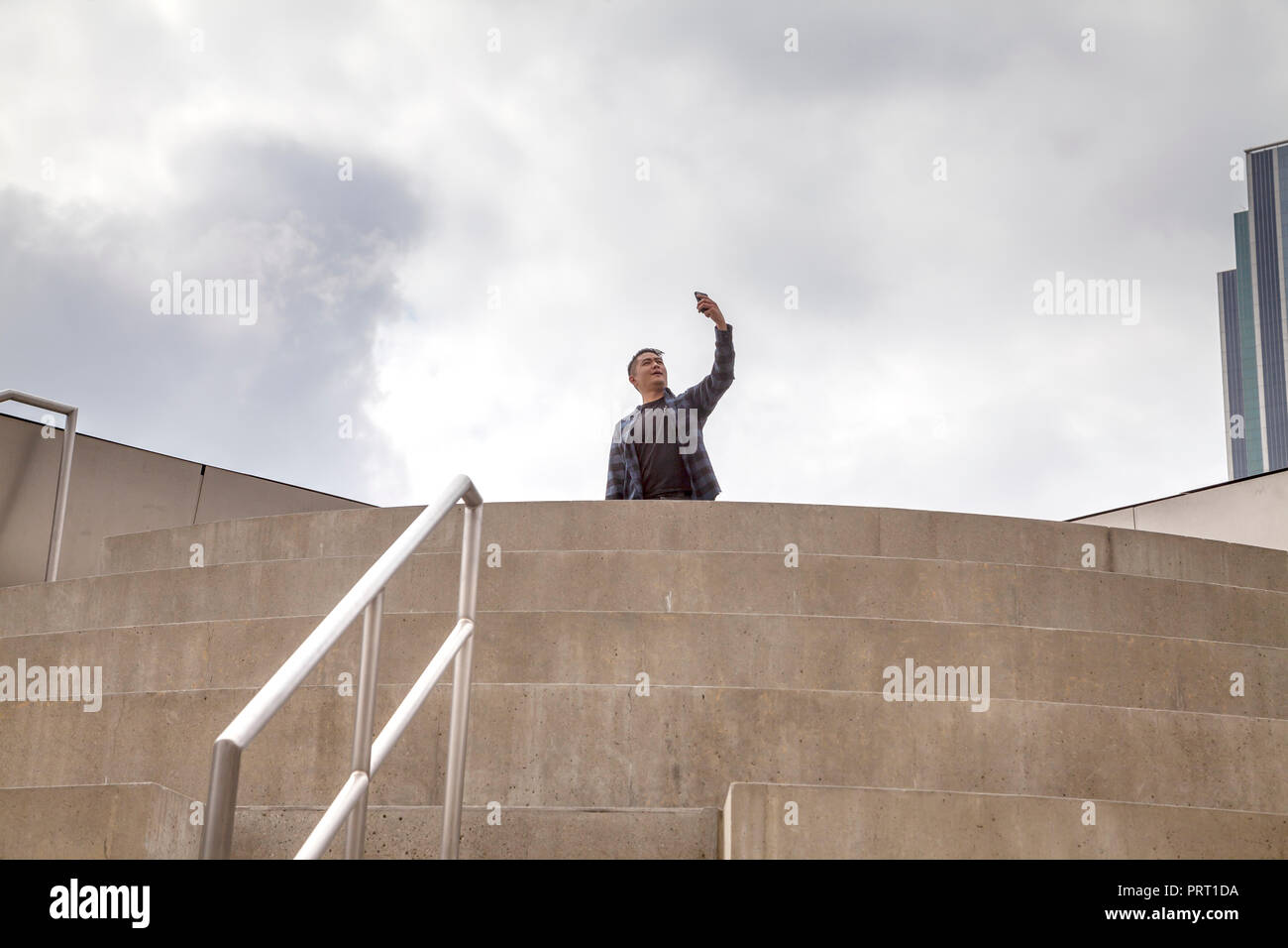 Joven hombre asiático teniendo selfie encima del techo del anfiteatro dentro de Walt Disney Concert Hall, Los Angeles, California, EE.UU. Foto de stock