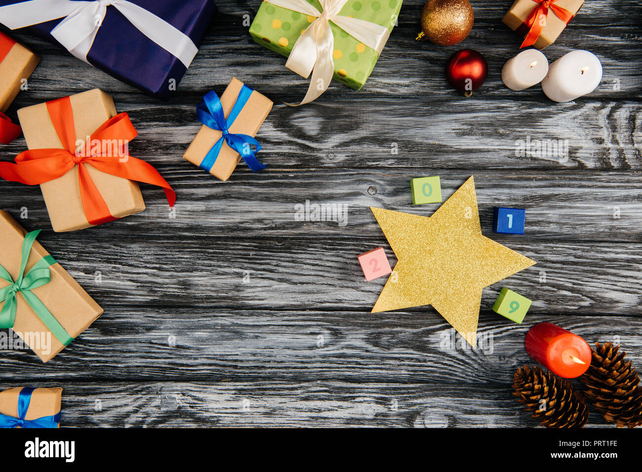 Vista superior de regalos de Navidad, 2019 firmar, estrella y quemando  velas sobre la superficie de madera Fotografía de stock - Alamy