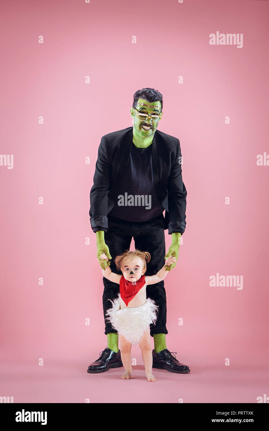 Familia de Halloween. Feliz el padre y los hijos niña recién nacida en  disfraz de Halloween y maquillaje. Tema: la sangrienta crazy maniak sobre  pink estudio antecedentes Fotografía de stock - Alamy