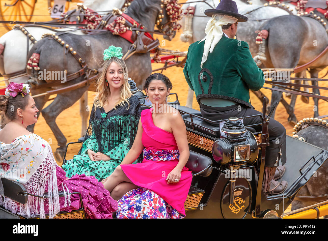 Sevilla, España - 15 de abril de 2018: jóvenes mujeres vestidas de  sevillanas tradicionales vestidos o trajes de flamenca en un carruaje  tirado por caballos en Sevilla Abril Fai Fotografía de stock - Alamy