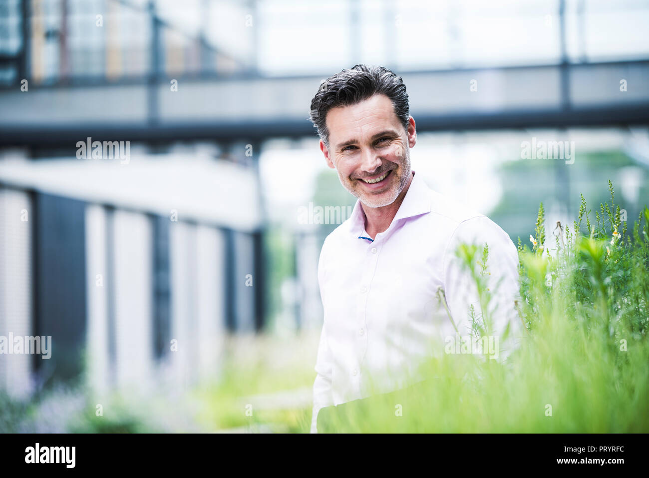 Retrato del empresario sonriente fuera del edificio de oficinas Foto de stock