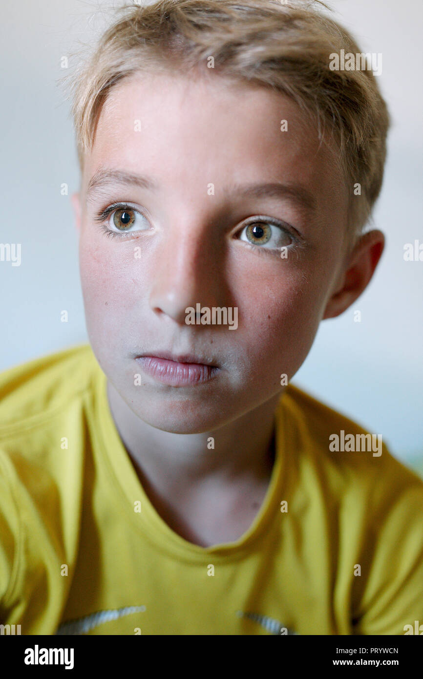 Retrato de muchacho rubio vistiendo camiseta amarilla Foto de stock