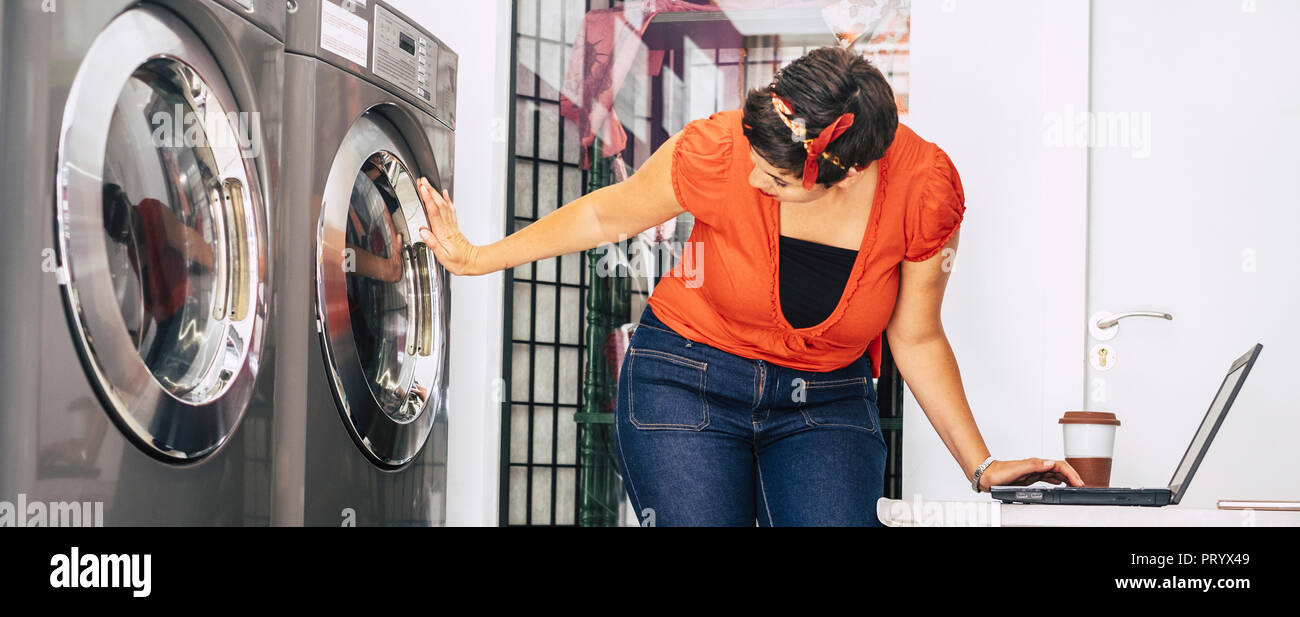 Señorita caucásica utilizar ordenador portátil en las lavanderías  automáticas servicio 24 h tienda mientras espera para su nuevo lavado y  limpieza de ropa de internet Fotografía de stock - Alamy