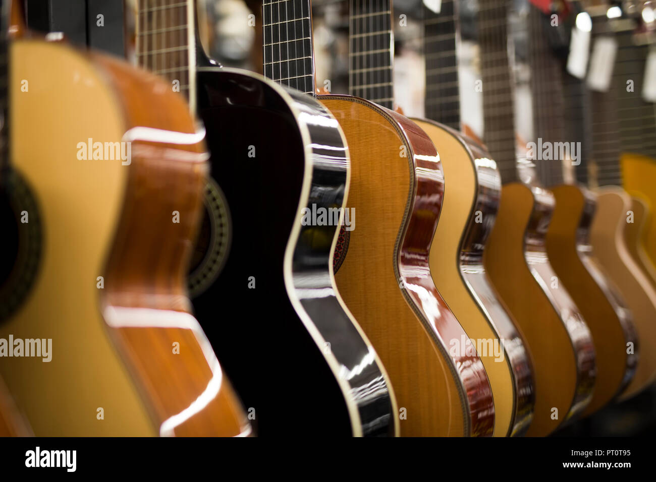 Vista cercana a las guitarras acústicas en fila en la tienda de música Foto de stock