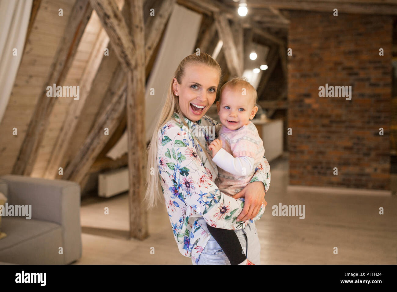 Retrato de madre feliz con su bebita en casa Foto de stock