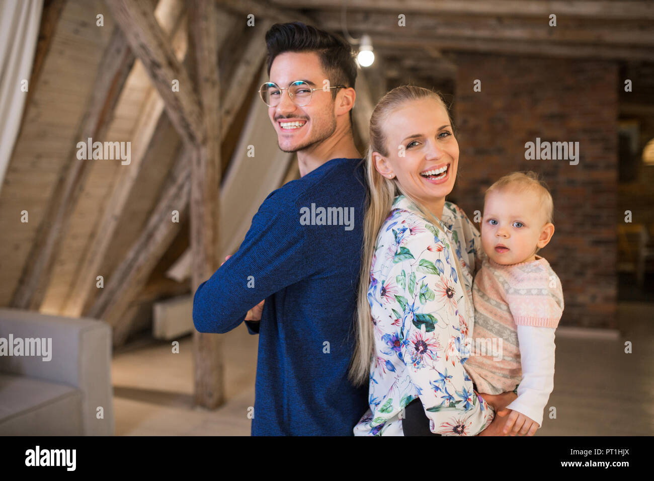 Retrato de los padres jóvenes felices con su niña en casa Foto de stock