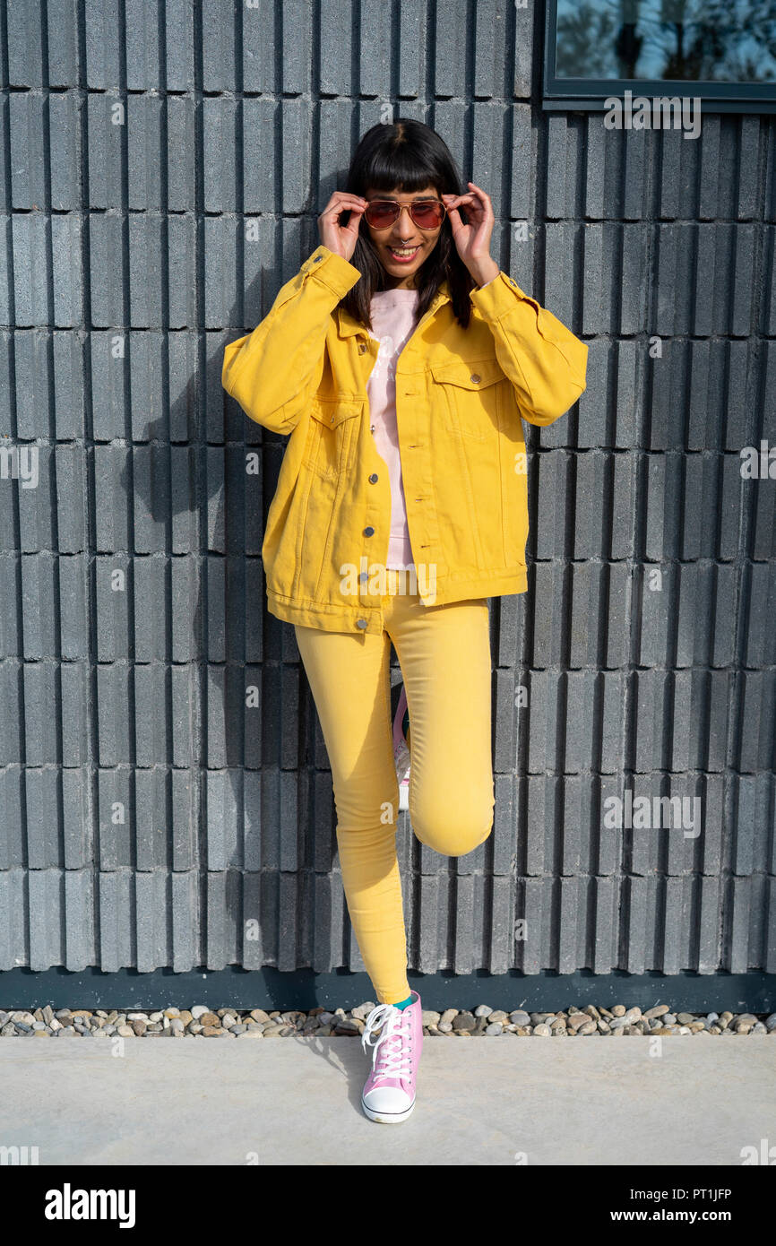 Mujer joven vistiendo ropa jeans amarillo Fotografía de stock - Alamy