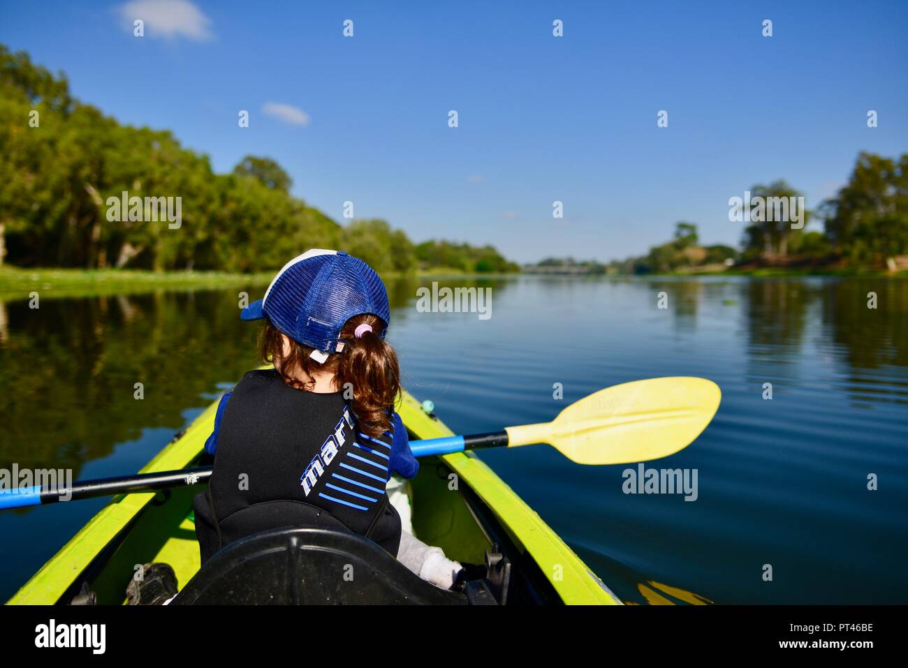 Niños remando en una canoa en el clima hermoso, Ross River QLD, Australia Foto de stock