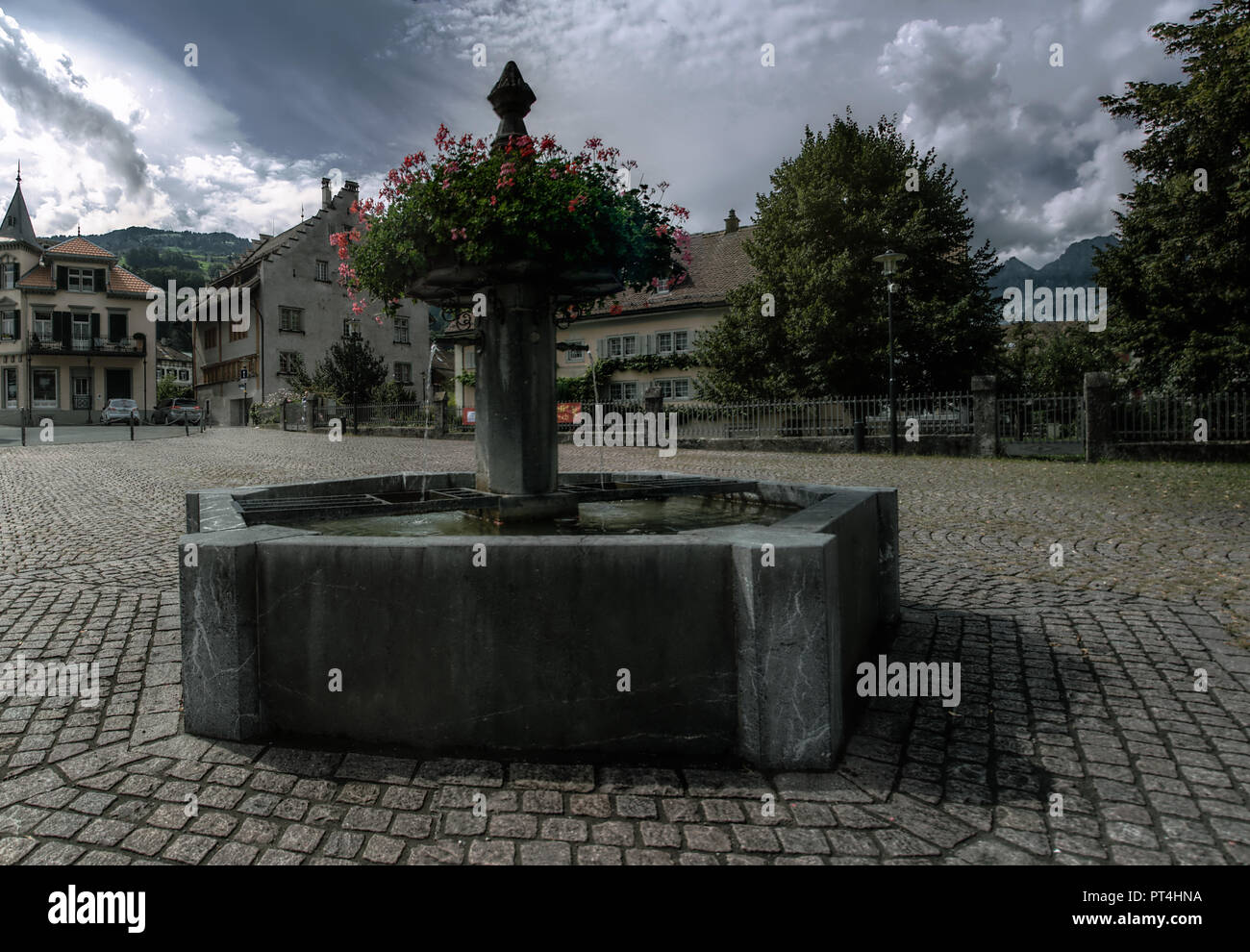 Fuente pública y geranios en Flums Alpes Suizos Foto de stock