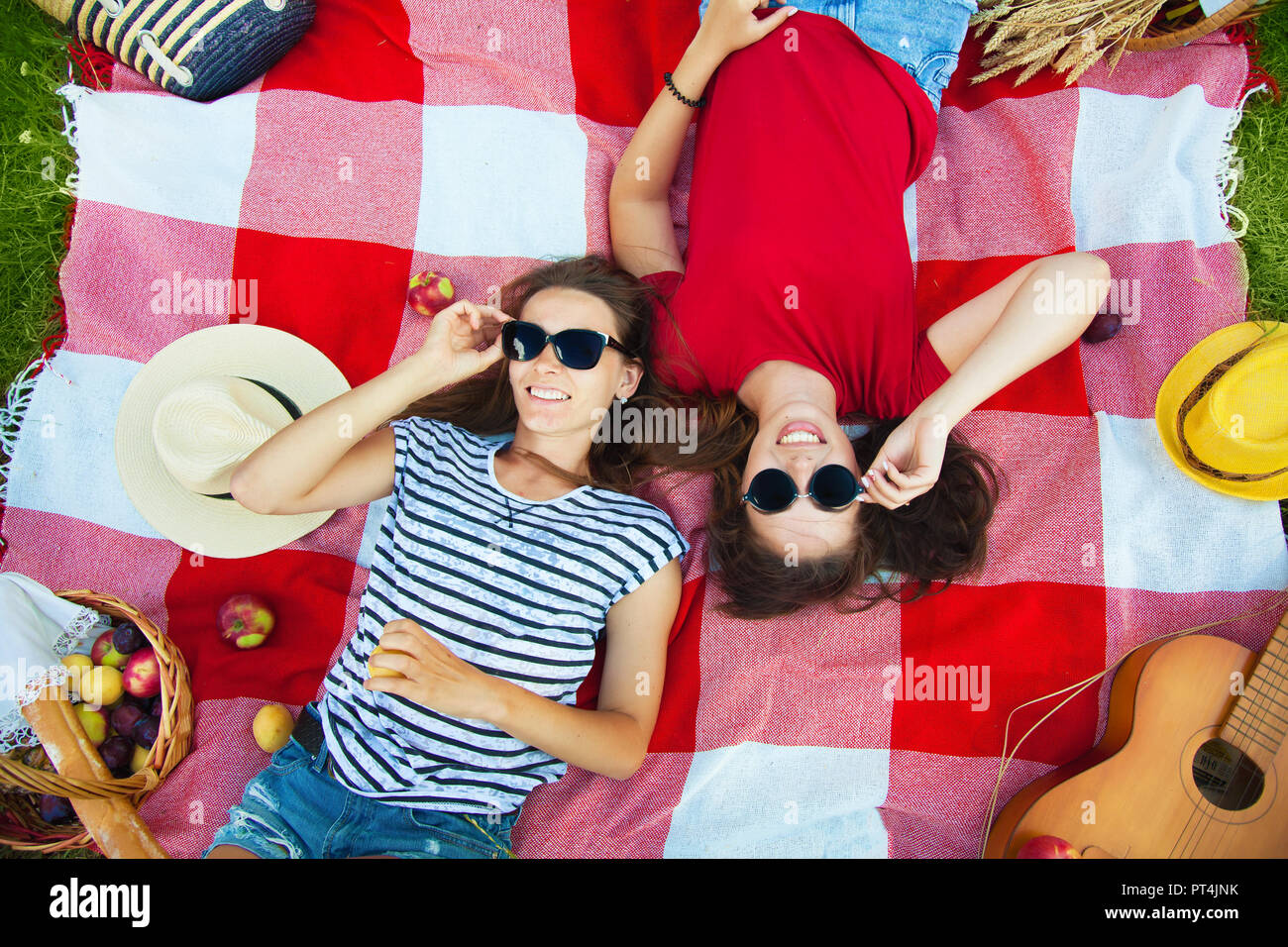 Dos chicas guapas en gafas de sol divirti ndose en un picnic en el