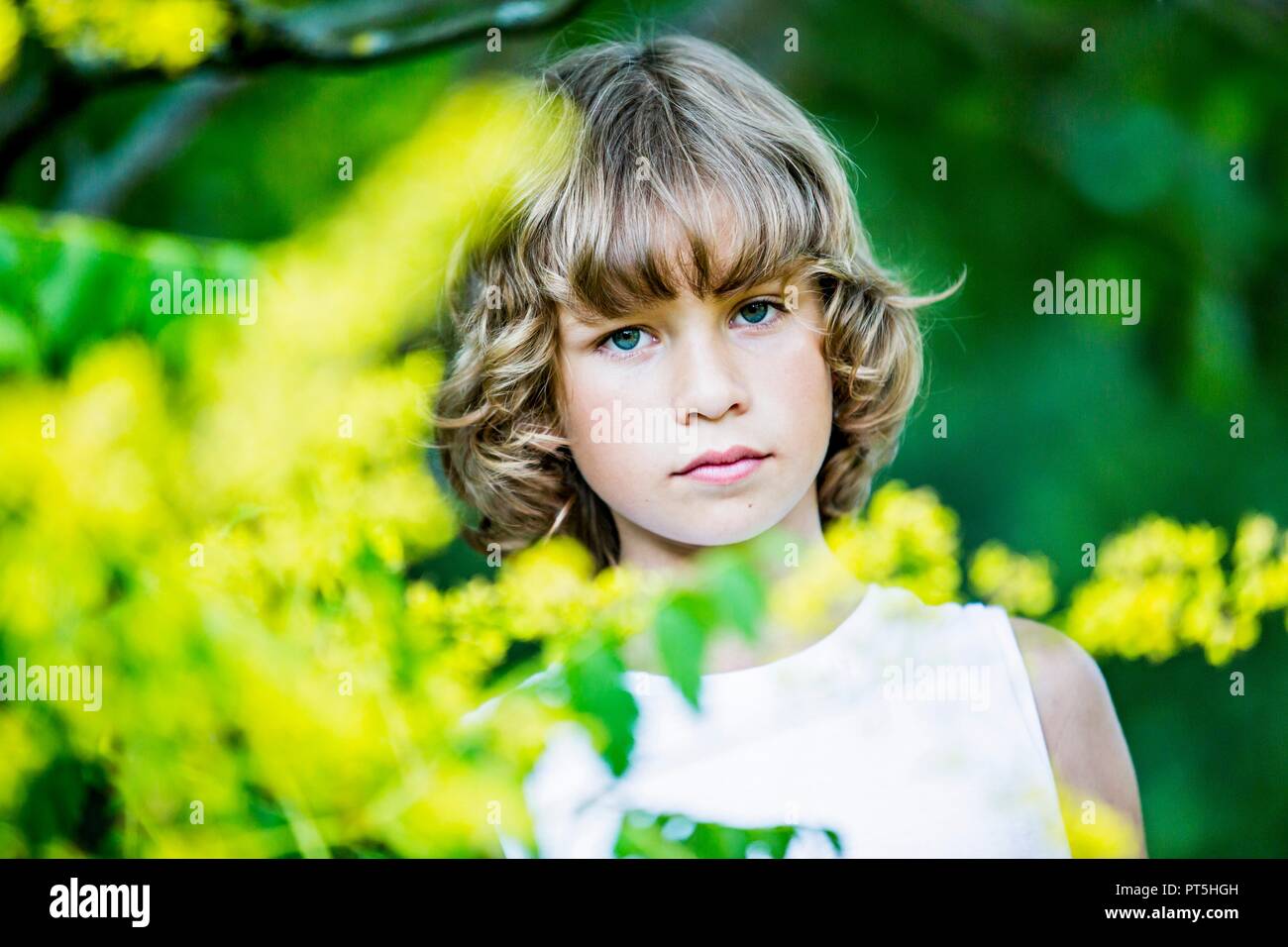 Retrato de joven con flores amarillas en primer plano. Foto de stock