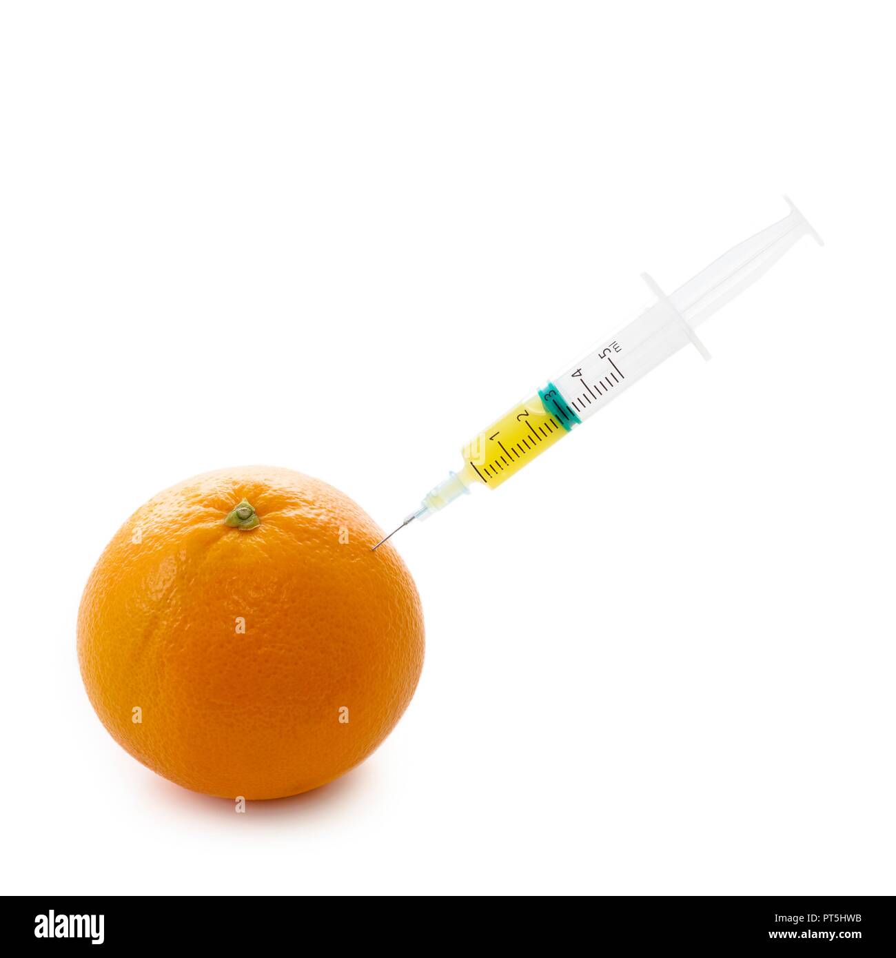 Naranja con jeringa. Foto de stock