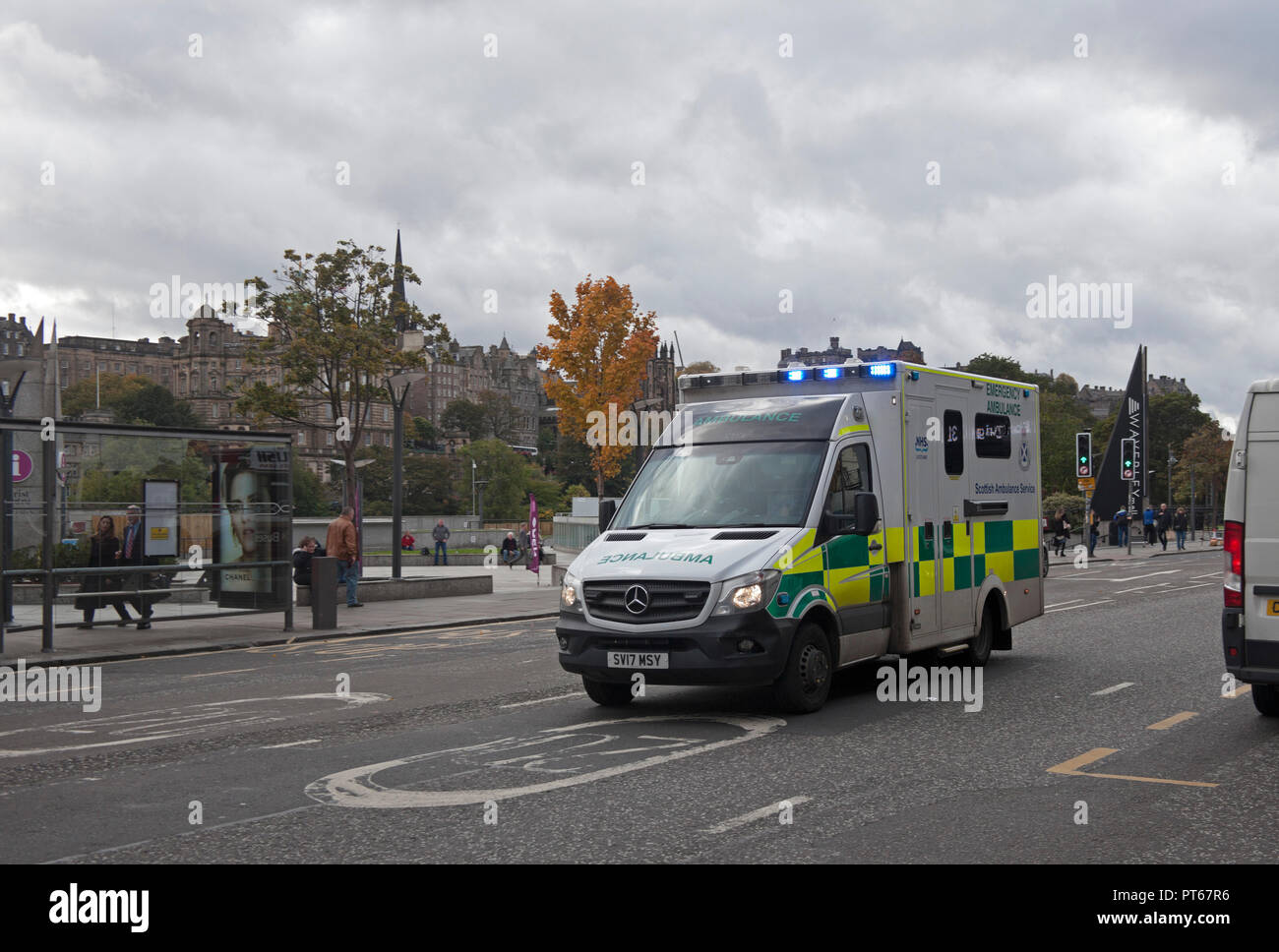 Ambulancia con luces azules aceleración en 20 zona de respuesta de emergencia, Princes Street, Edimburgo, Escocia, Reino Unido Foto de stock