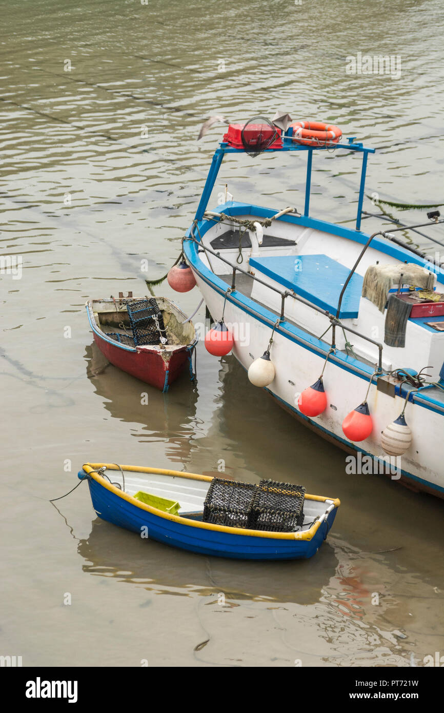 Barco de pesca y dos pequeños botes a remo. Metáfora para la