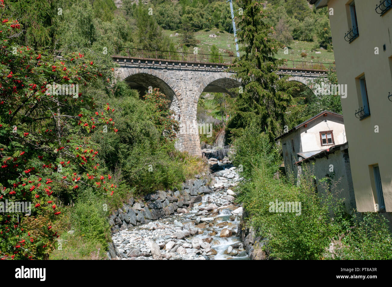 Arcos de piedra del puente del tren sobre un arroyo en Lavin es un municipio en el distrito de Inn, en el cantón suizo de los Grisones Foto de stock