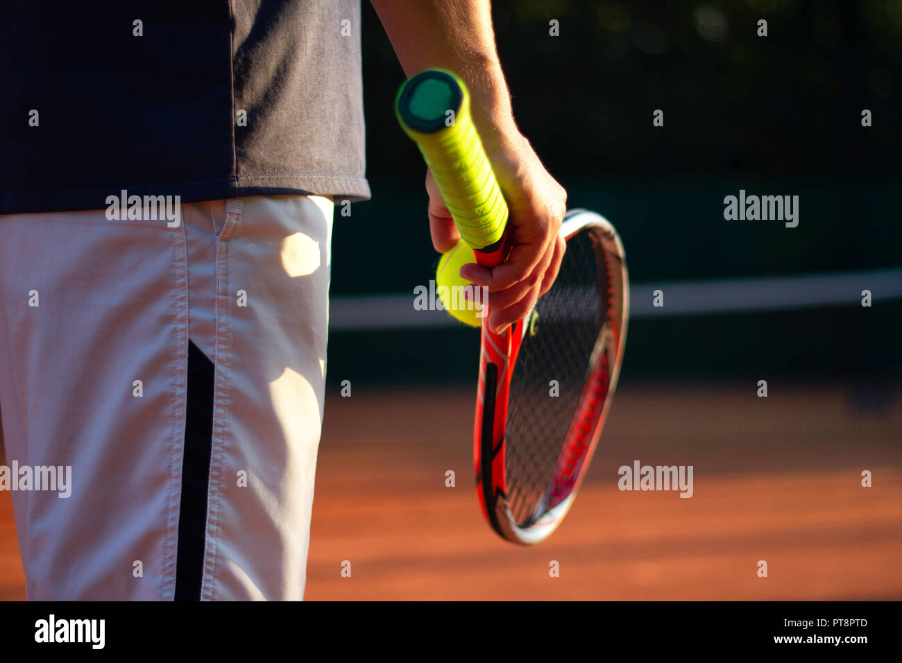 Un jugador de tenis se prepara para servir una pelota de tenis durante un partido Foto de stock