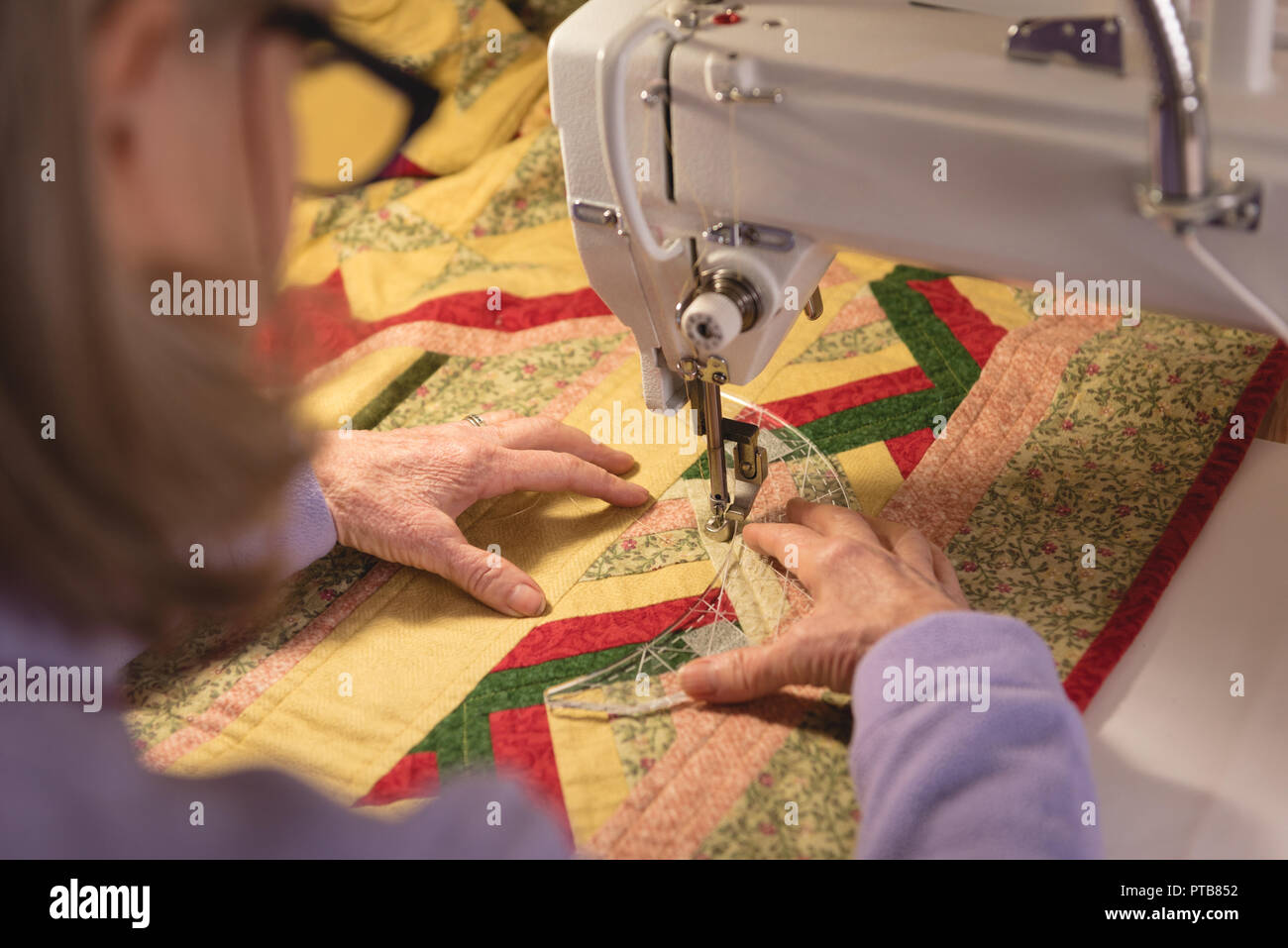 Mujer cose ropa en máquina de coser Foto de stock