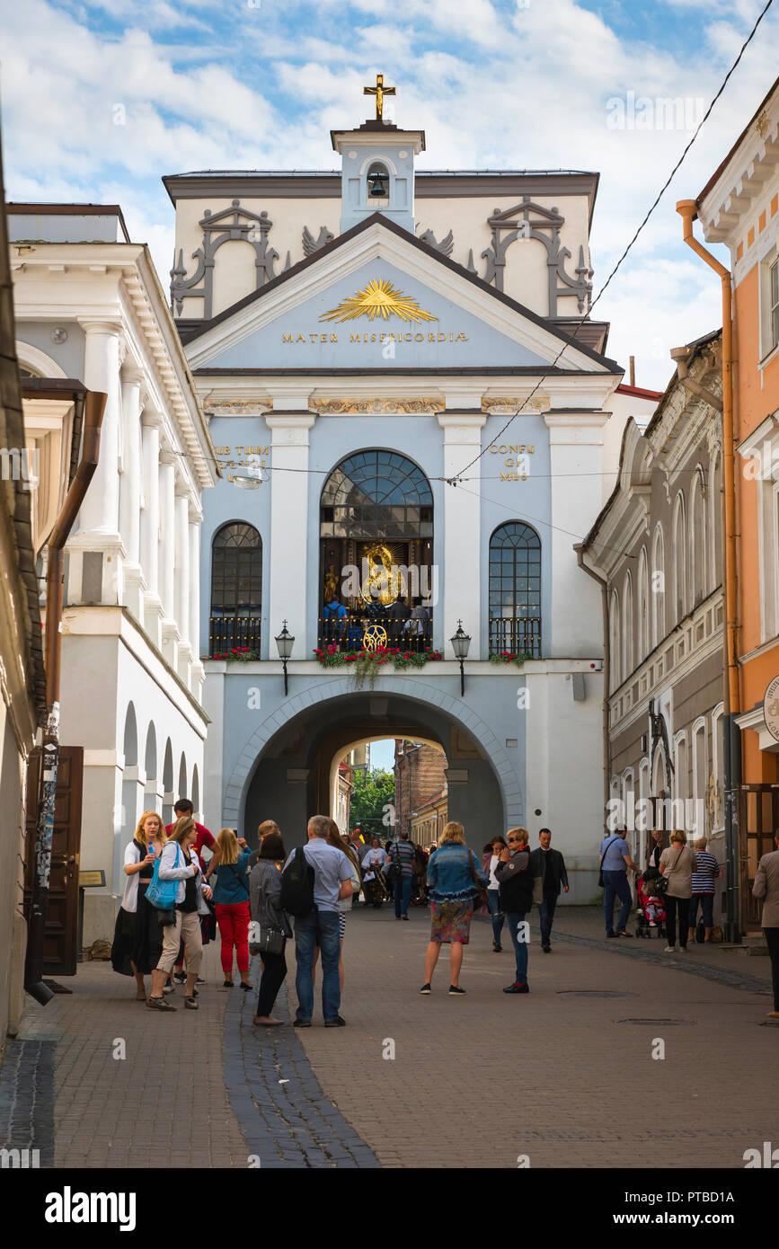 Capilla de las puertas de la Aurora, en la ciudad antigua de Vilnius la gente mira hacia una ventana de la capilla de revelar el santuario de la Virgen de las puertas del amanecer. Foto de stock