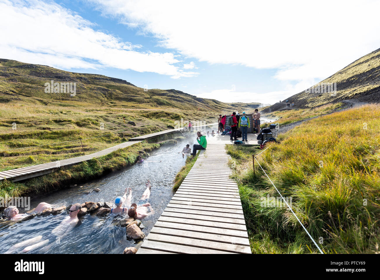 Hveragerdi, Islandia - Septiembre 18, 2018: muchas personas nadar y bañarse en aguas termales de trail en Reykjadalur, durante el día de otoño en el sur de Islandia, gol Foto de stock