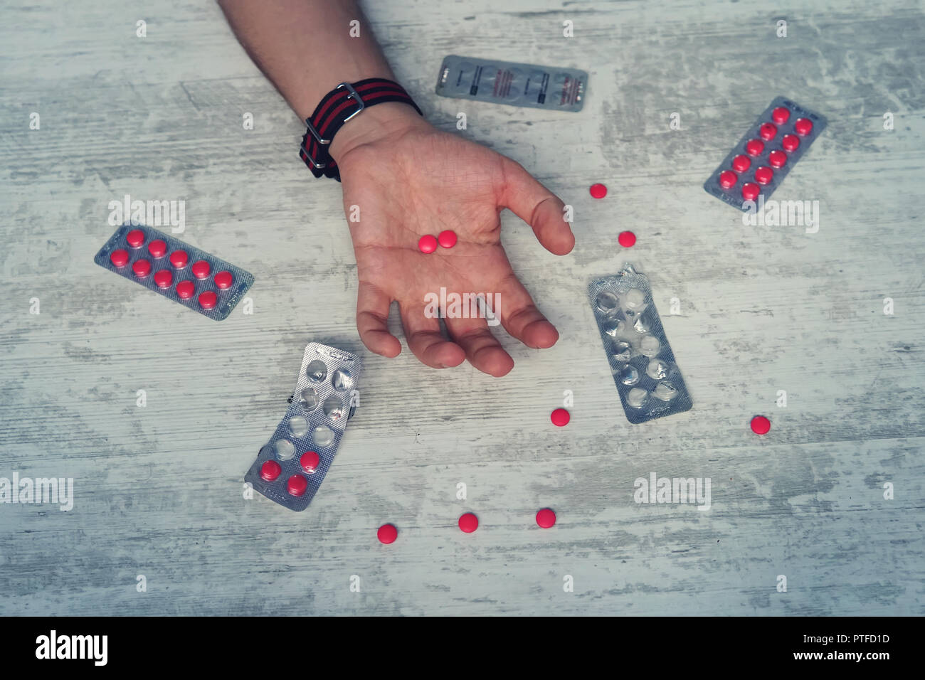Cerca de sobredosis de píldoras y adicto a las manos de los hombres, el hombre el suicidio por sobredosis de medicamentos. pastillas de color rojo en la mano de un joven Foto de stock