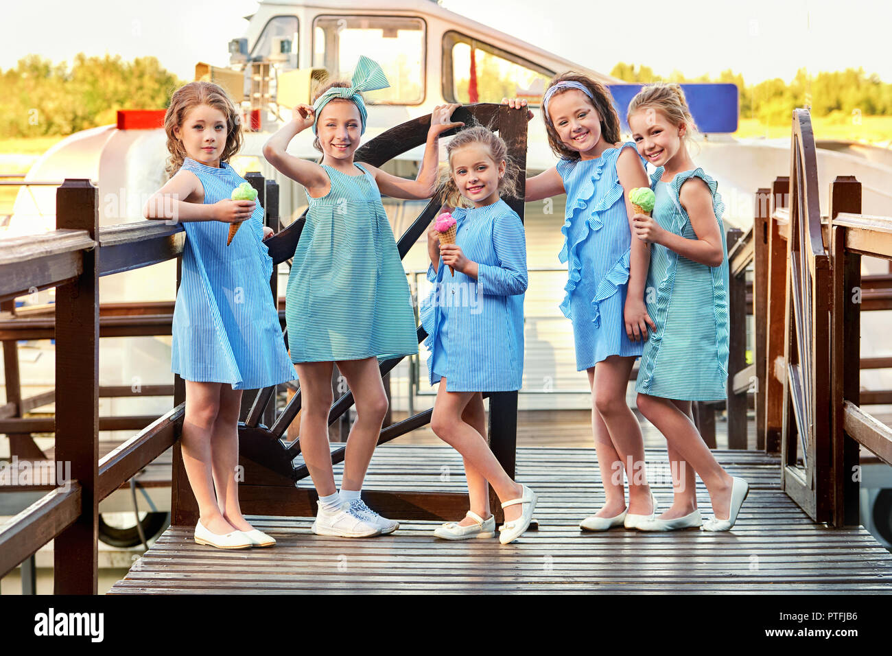 Grupo 5 cinco chicos en dama moda elegante vestidos rayas,estilo marino. Las niñas colección diseñador de ropa para niños. Novias sonrisa el Vacaciones,concepto de moda Fotografía de stock -