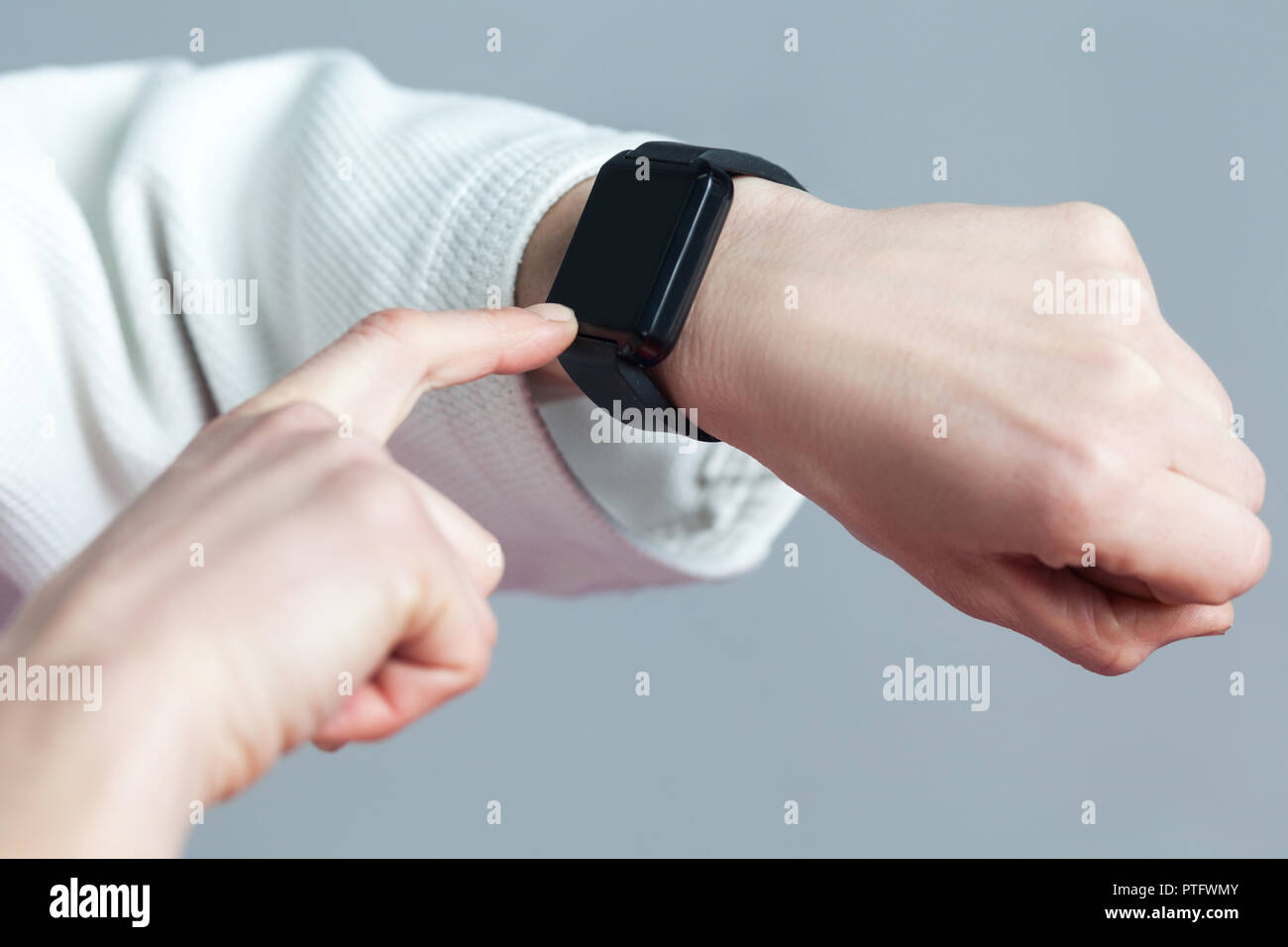 Lado femenino con smartwatch son toching comprobando con el dedo y quemar calorías en smart watch pulsera de dispositivo. Deporte y salud concepto. Interior Foto de stock