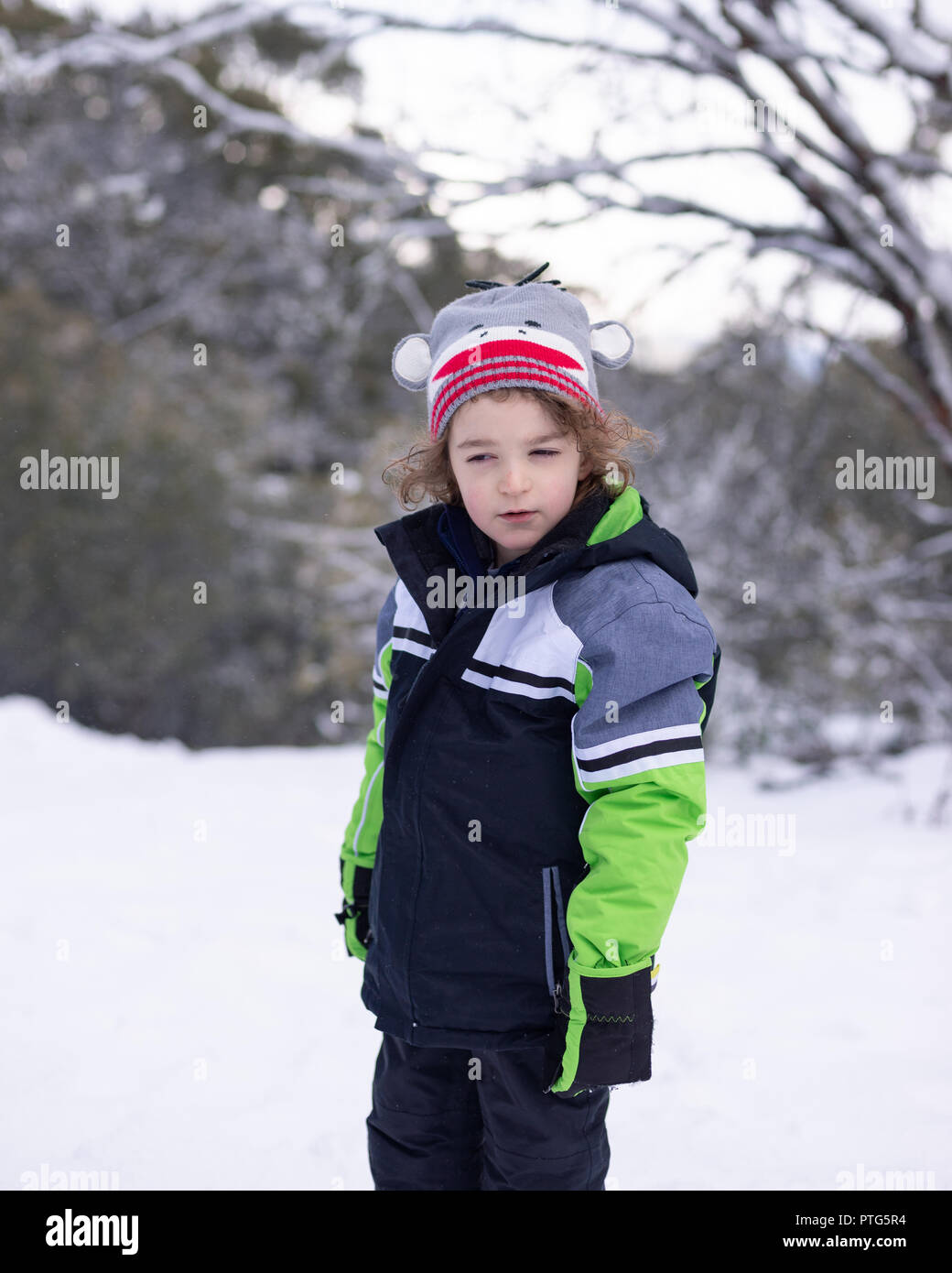 Retrato de un joven en la nieve con un cuestionamiento de la expresión en su rostro. Foto de stock