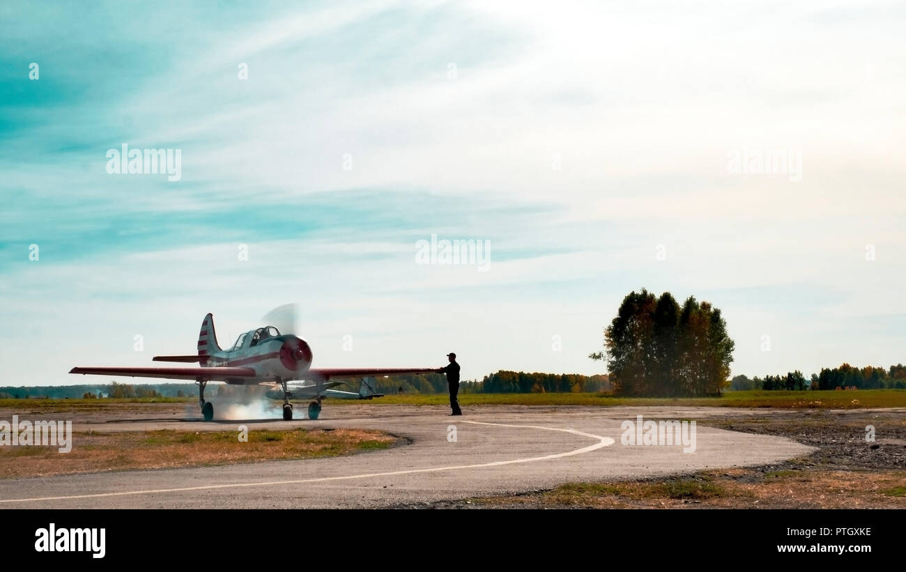 Vista del avión en el aeródromo de hierba de cerca; clásico avión de despegue en la pista de rodadura; entrenamiento acrobático vuelo de oldschool aviones; ley de ocio Foto de stock