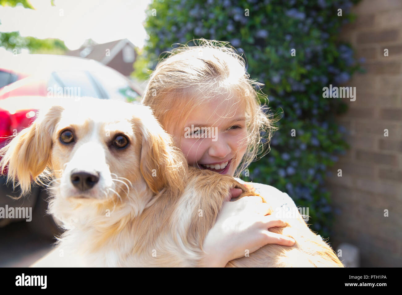 Niña feliz abrazando perro Foto de stock