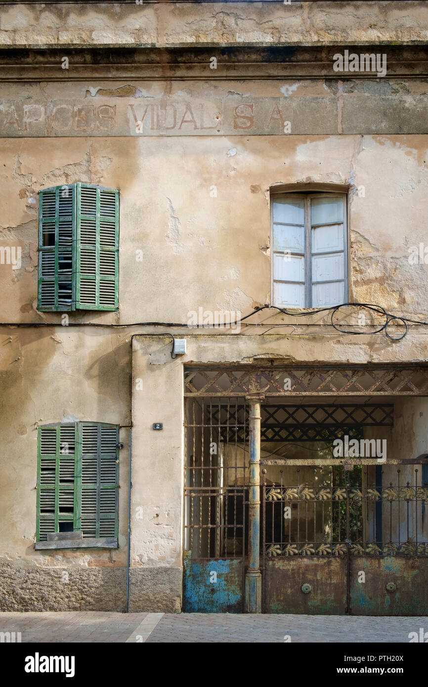 Tiempo gastado oxidada, persianas y puertas de hierro forjado en la fachada de un edificio en el casco antiguo de la ciudad, Alcudia, Mallorca, España Foto de stock