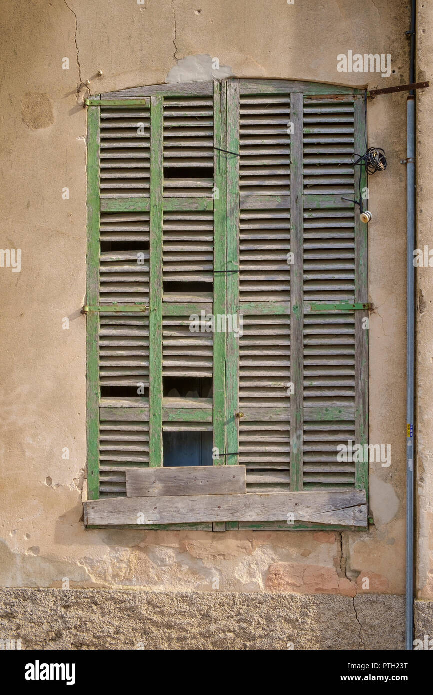 Reparado pero deteriorado y tiempo gastado obturador verde en un edificio antiguo en Alcudia, Mallorca, España Foto de stock