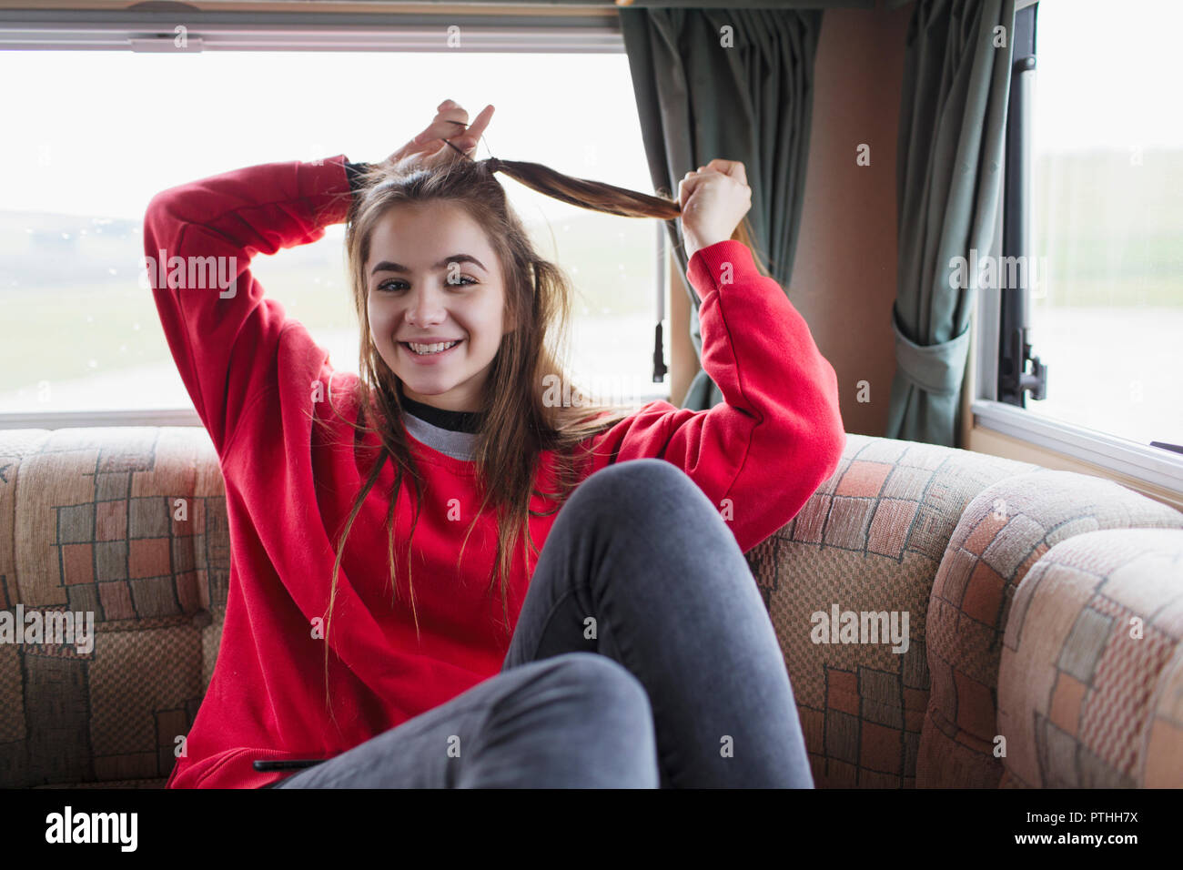Retrato sonriente adolescente cabello fijación en motor home Foto de stock