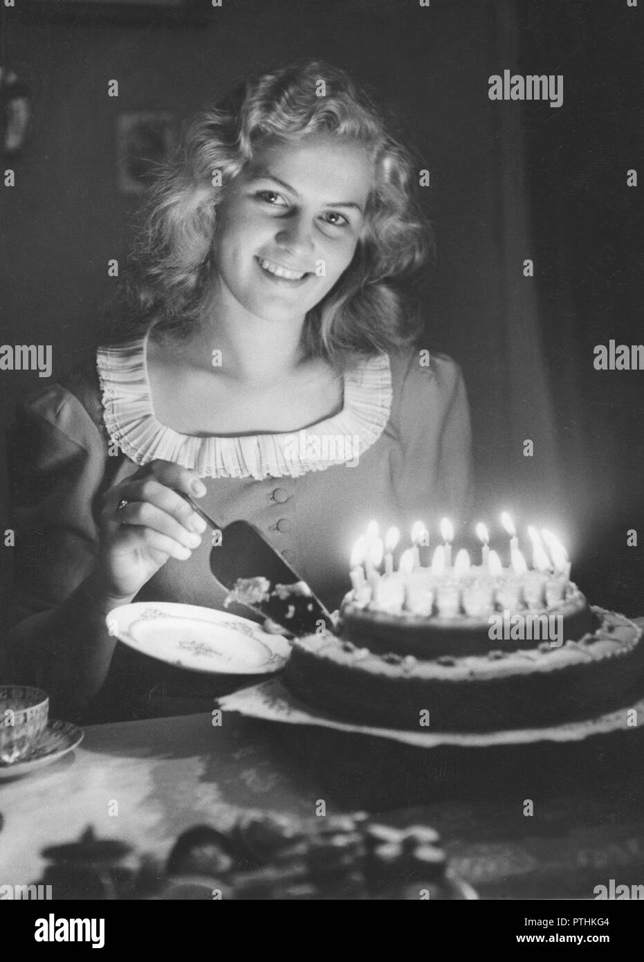 Navidad en la década de 1940. Stockholms Lucía año 1945, Gurli Holmberg está cortando un trozo del pastel de Lucia. Suecia 1945 Foto de stock