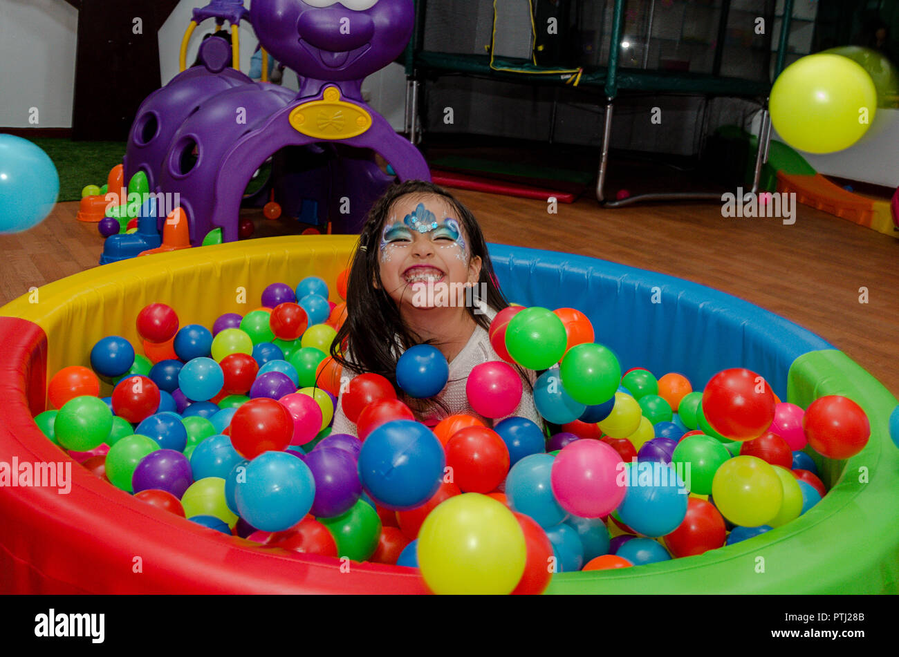 Niña arrojando a sí misma en una piscina llena de bolas de colores en una  fiesta de cumpleaños Fotografía de stock - Alamy