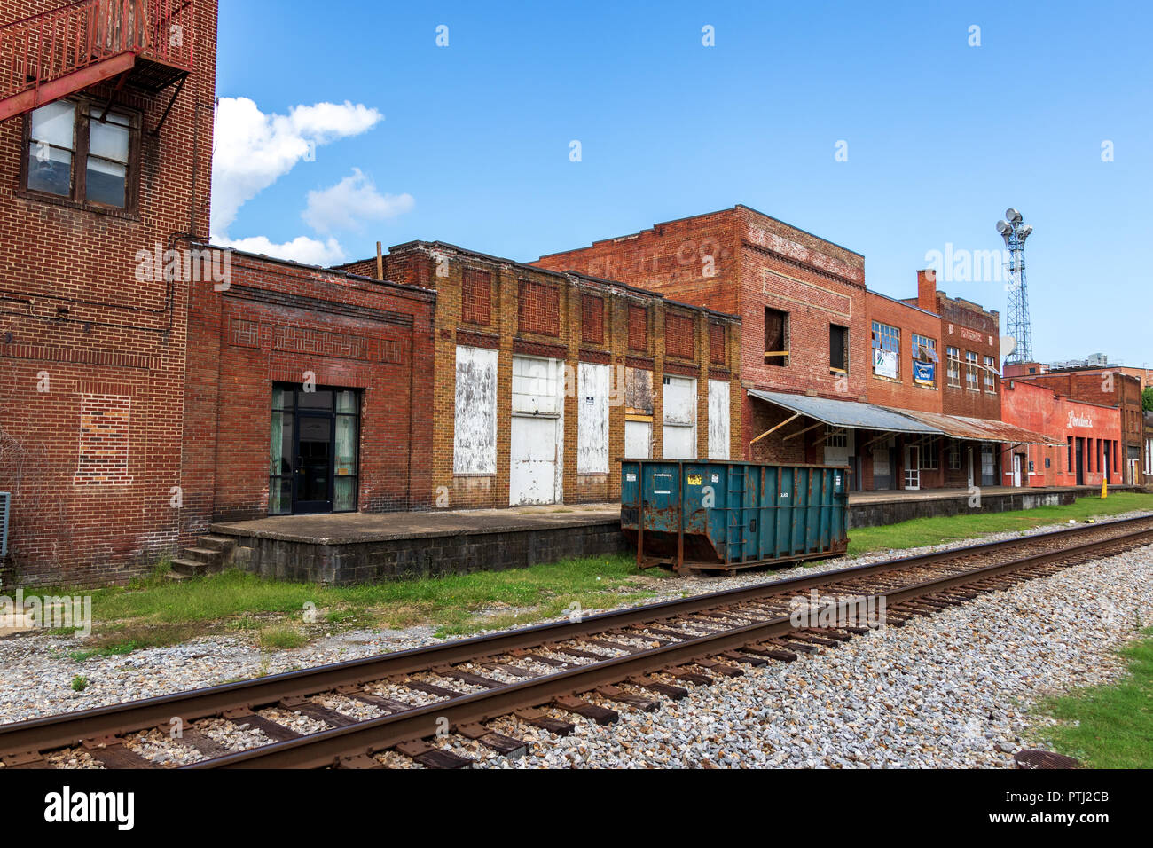 JOHNSON CITY, TN, USA-9/30/18: Una línea de antiguos, principalmente almacenes vacíos, frente a la vía del ferrocarril funcionando a través del centro de la ciudad. Foto de stock